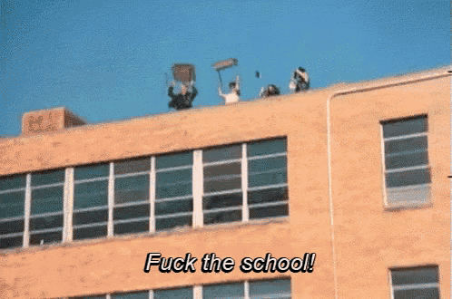 a group of people on the roof of a building with the words " fuck the school " written below them
