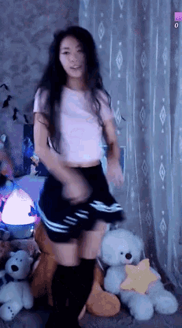 a girl in a pink shirt and black skirt is dancing