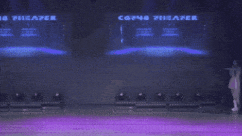 a group of women are dancing on a stage with a large screen behind them that says ' cosme ' on it