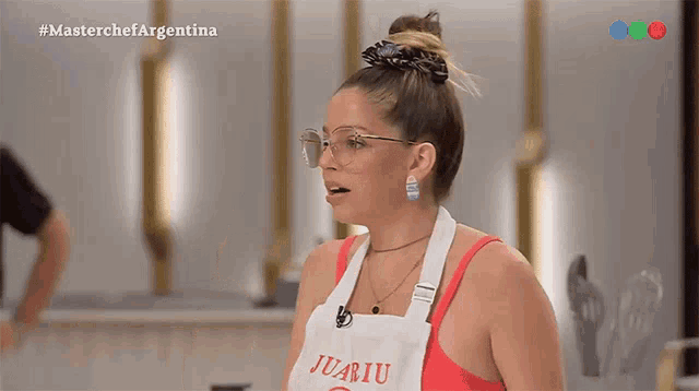 a woman wearing glasses and an apron that says juariu