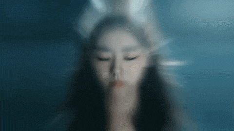 a blurry picture of a woman with her eyes closed behind a glass