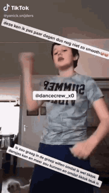 a young boy is dancing in a room with a dog behind him .