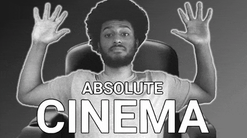 a man sitting in a chair with his hands in the air and the words absolute cinema behind him