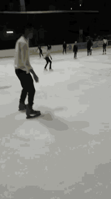 a group of people are ice skating in a rink