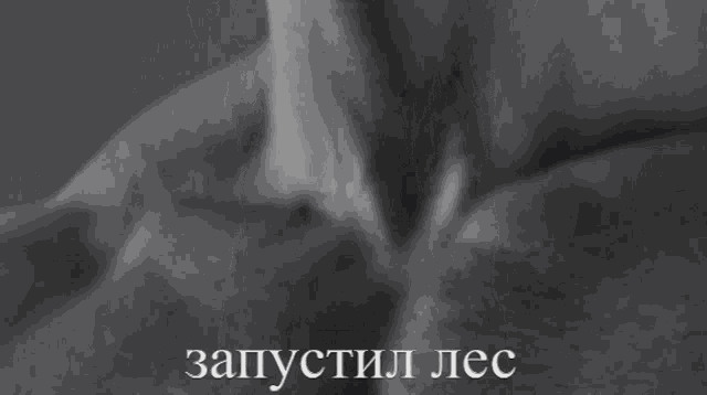 a black and white photo of a person 's face with russian writing on the bottom