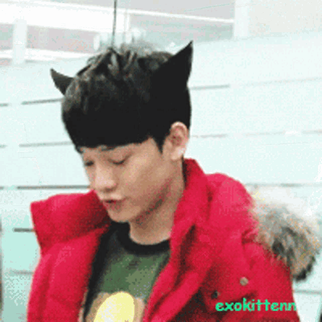 a man wearing a red jacket with exokitten written on the bottom