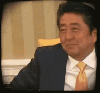 a man in a suit and tie is looking at the camera .