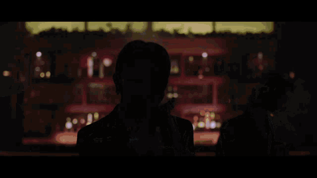three women in suits and ties are standing in a dark room