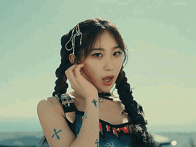 a woman with braids has a tattoo on her arm that says ' x '