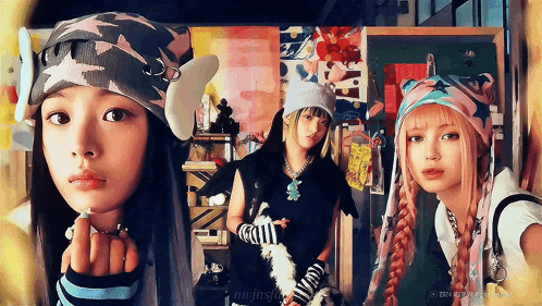three girls are standing next to each other with one wearing a hat that says n on it