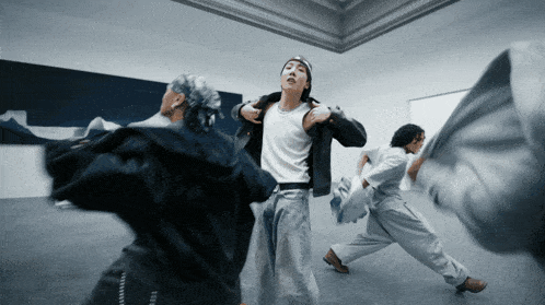 a group of people are dancing in a room and one of them is wearing a shirt that says ' i love you '