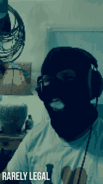 a man wearing headphones and a ski mask has the words rarely legal below his face