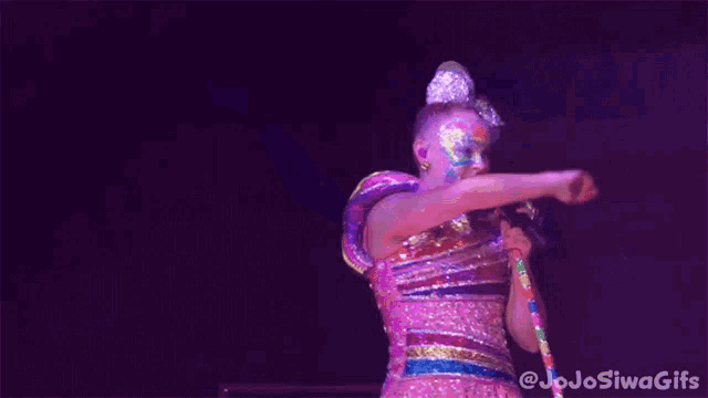 a girl singing into a microphone with jojo siwa gifs written on the bottom right