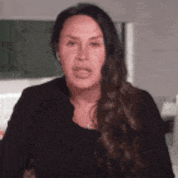 a woman with long brown hair is making a funny face .