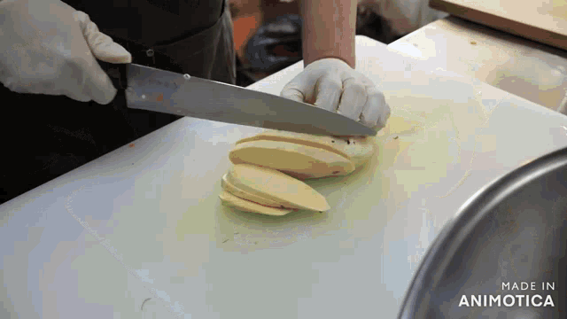 a person is cutting a piece of food on a cutting board with the words made in animotica on the bottom