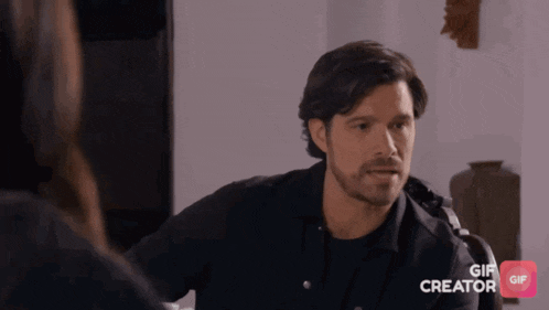 a man in a black shirt is talking to a woman in a gif creator app