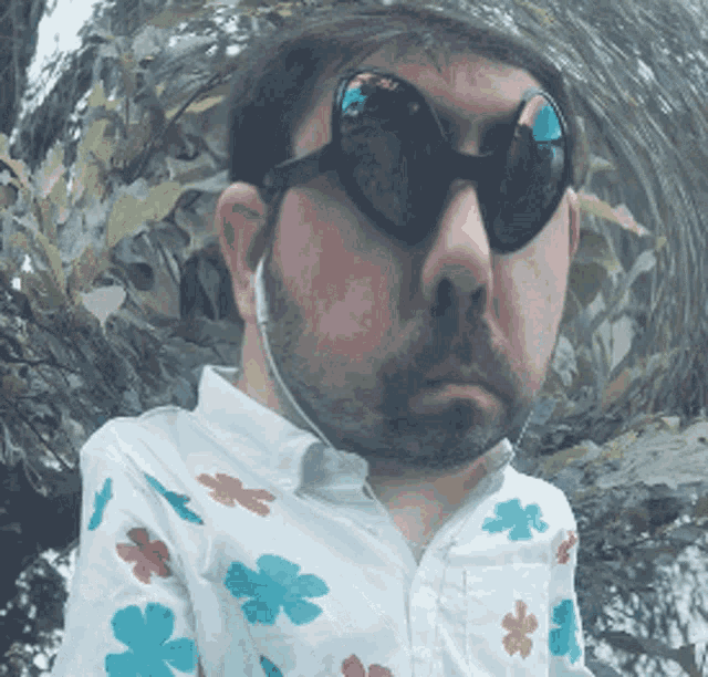 a man with a beard wearing sunglasses and a floral shirt