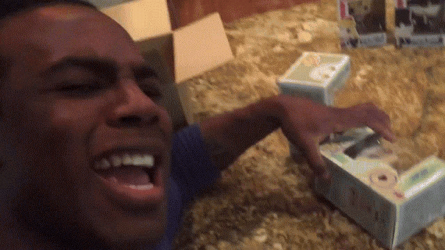 a man with his mouth open is holding a box that has a picture of a cat on it