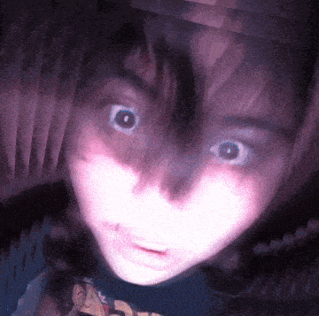 a close up of a person 's face with a purple background and a shirt that says ' a ' on it