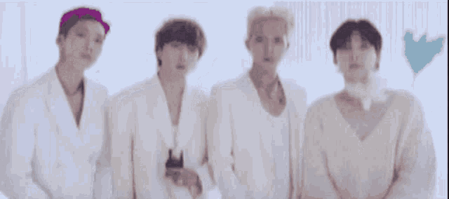 a group of young men are standing next to each other in white clothes .