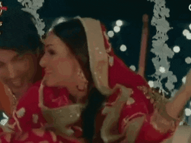 a bride and groom are sitting next to each other on a swing .