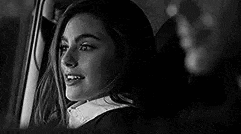 a woman is sitting in the driver 's seat of a car .