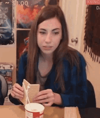 a woman is sitting at a table with a cup of milk and a piece of cake in her hands ..