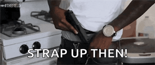 a man is holding a gun in his pocket and the words `` strap up then '' are written above him .