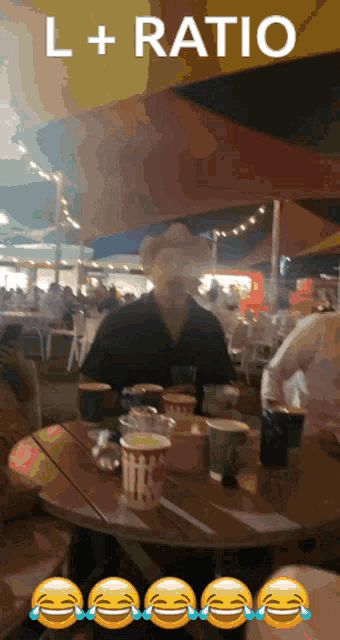 a man in a cowboy hat sits at a table in front of a sign that says " l + ratio "