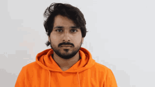 a man with a beard wearing a bright orange hoodie