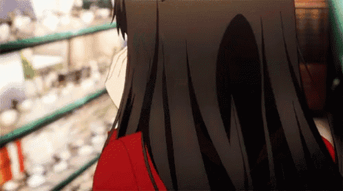 a girl with long black hair is standing in front of a store shelf looking at something