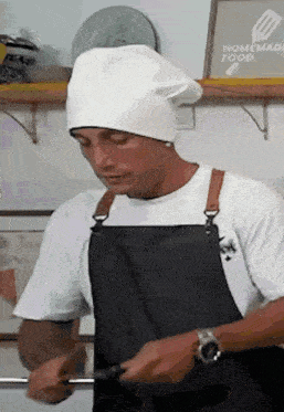 a man wearing a chef 's hat and apron prepares food in front of a homemade food sign