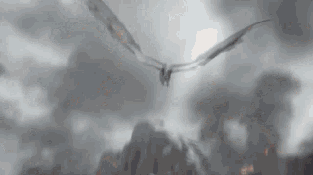 a dragon is flying through the air over a mountain .