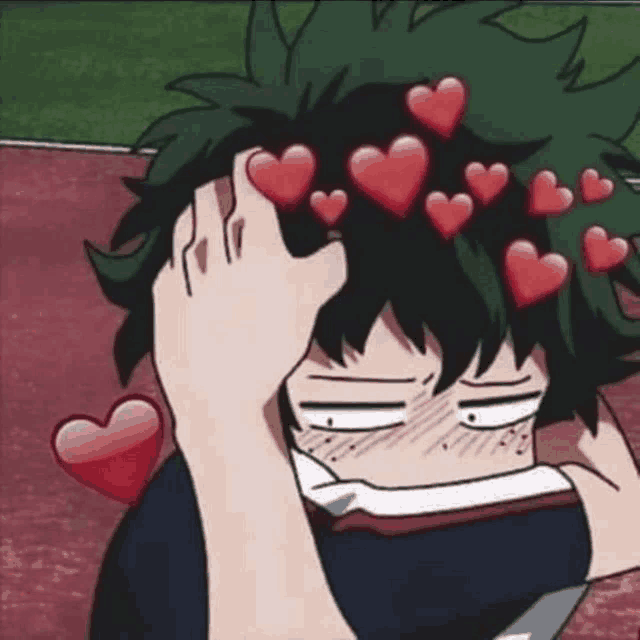 a boy with hearts on his head is covering his face .