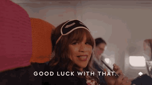 a woman wearing a sleep mask is sitting on an airplane and says good luck with that