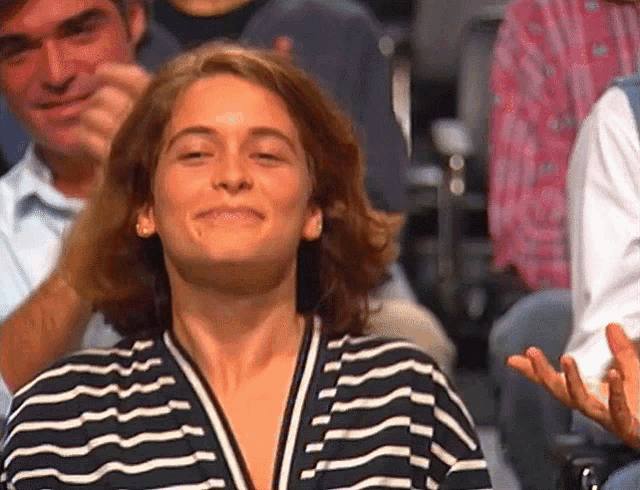 a woman wearing a black and white striped shirt is smiling