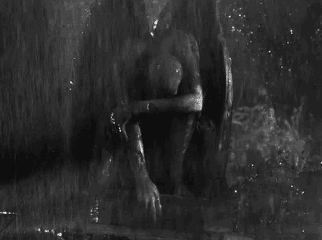 a black and white photo of a man in the water