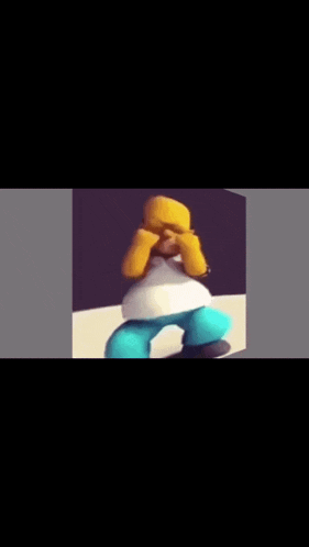 homer simpson is sitting on a table with his hands on his face .