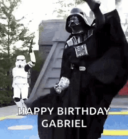 a person in a darth vader costume is dancing in front of a stormtrooper .