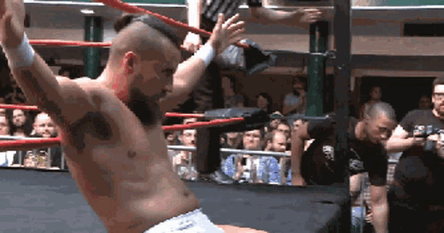 a man in a wrestling ring with a tattoo on his chest that says ' a ' on it