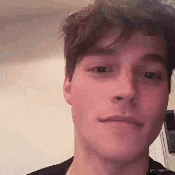 a close up of a young man 's face with the words lovingpost on the bottom
