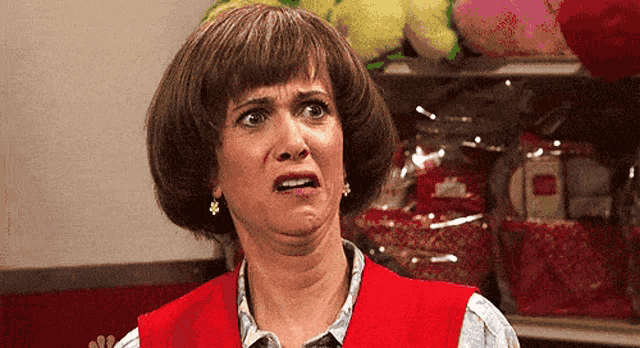 a woman in a red vest is making a face
