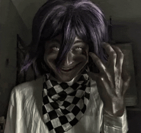 a person with purple hair and a checkered scarf is wearing a costume .