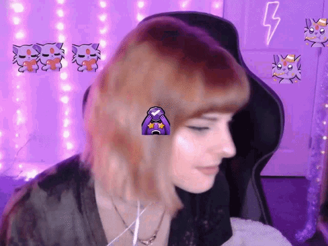 a woman is sitting in a chair with a purple lightning bolt on the wall behind her .