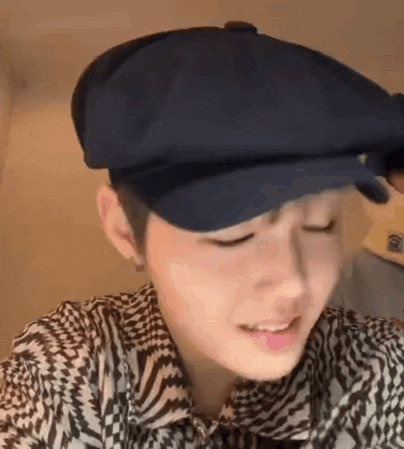 a close up of a person wearing a hat and a shirt .