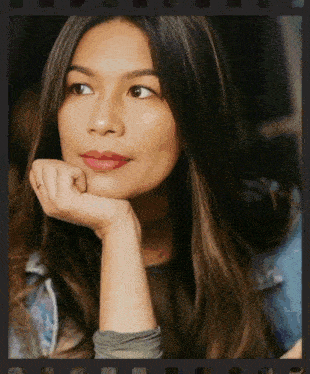 a woman with her hand on her chin looks to her left