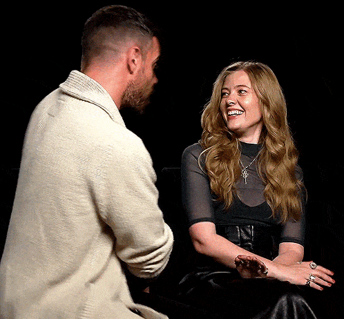a man and a woman are looking at each other and the woman is smiling