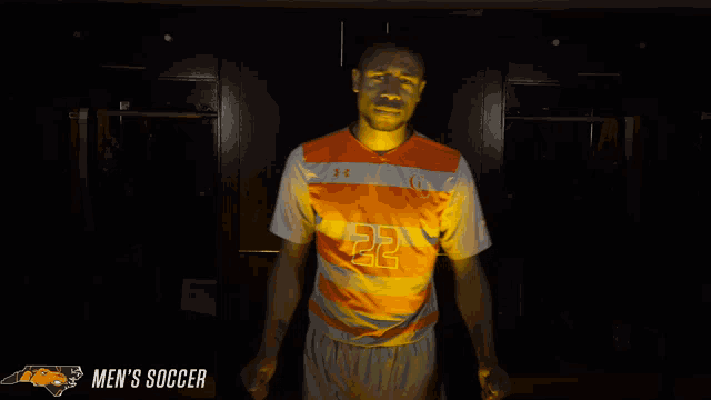 a man wearing an orange and white jersey with the number 22 on it