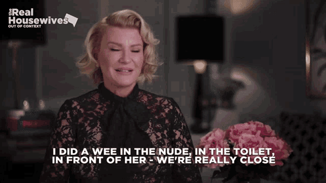 a woman in a black lace top says " i did a wee in the nude "