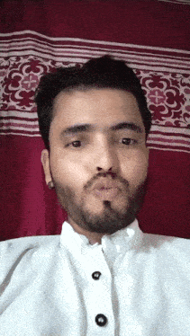 a man with a beard is blowing a kiss